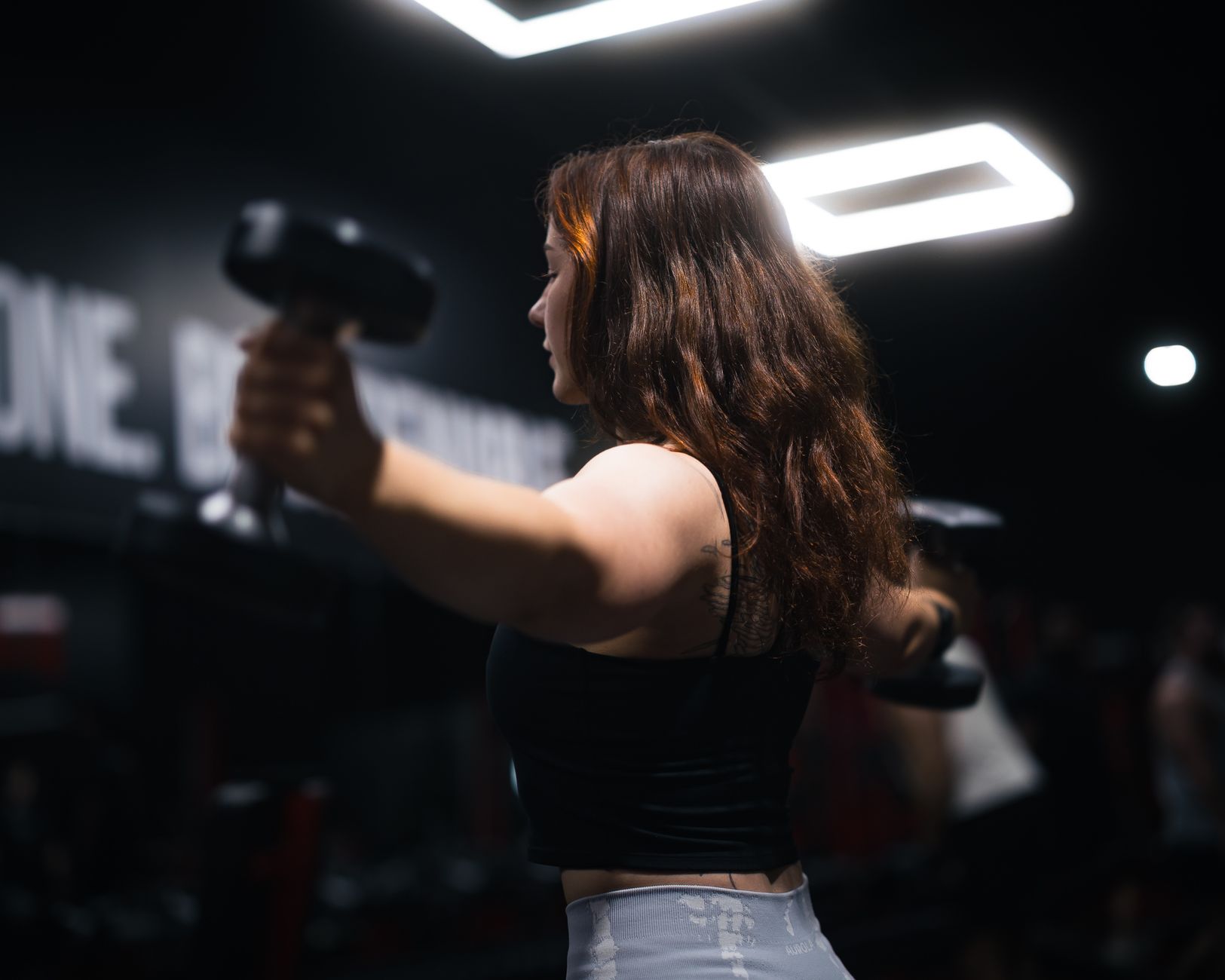 Mulher treinando musculação em academia moderna